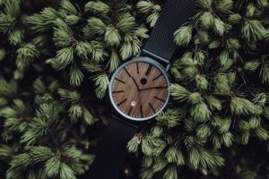 Kovové hodinky s dřevěným ciferníkem a firemním logem